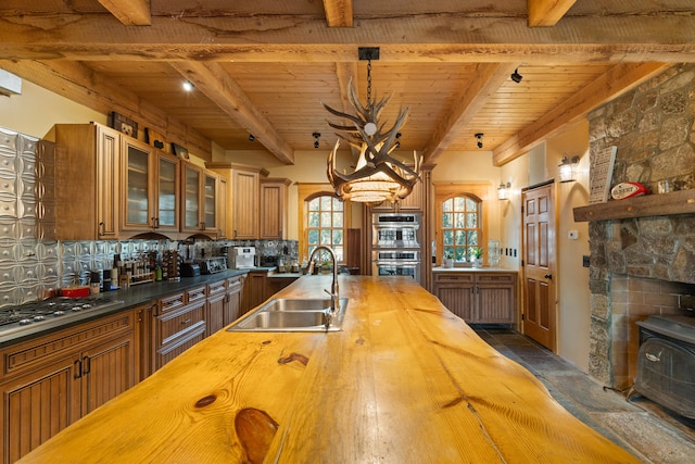 kitchen with beam ceiling, decorative backsplash, sink, and wood ceiling