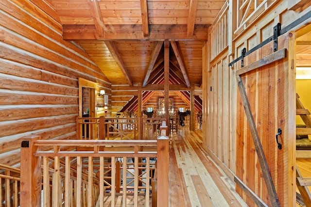 wine area featuring hardwood / wood-style floors, wooden ceiling, vaulted ceiling with beams, and a barn door