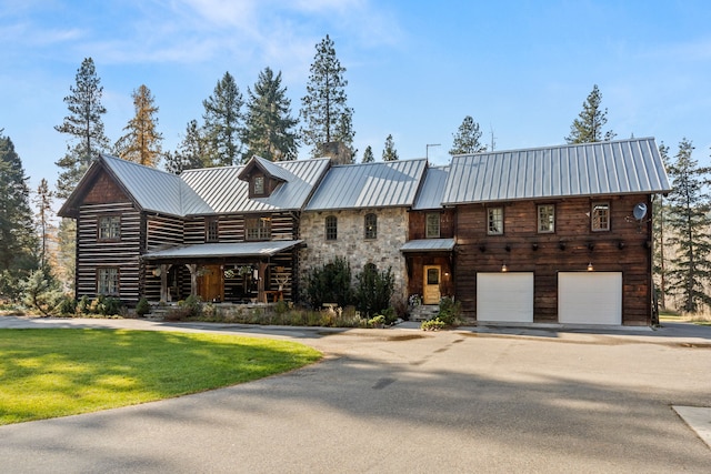 log cabin featuring a front yard and a garage