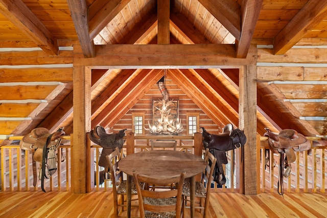 dining area featuring vaulted ceiling with beams, wood walls, hardwood / wood-style flooring, an inviting chandelier, and wood ceiling