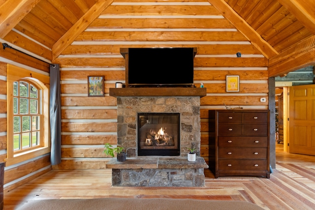 unfurnished living room with beamed ceiling, light hardwood / wood-style flooring, a stone fireplace, and wood ceiling