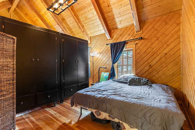 bedroom featuring vaulted ceiling with beams, wooden walls, light hardwood / wood-style floors, and wooden ceiling