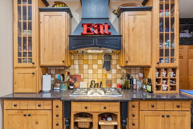 kitchen with tasteful backsplash, dark stone countertops, custom range hood, and stainless steel gas stovetop