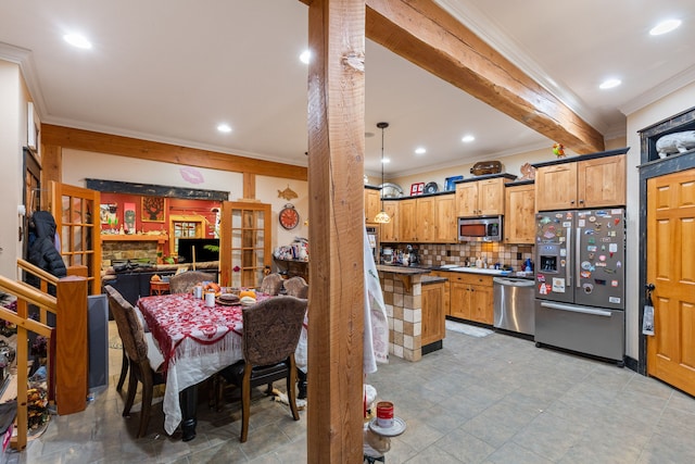 kitchen featuring beamed ceiling, appliances with stainless steel finishes, decorative light fixtures, and ornamental molding