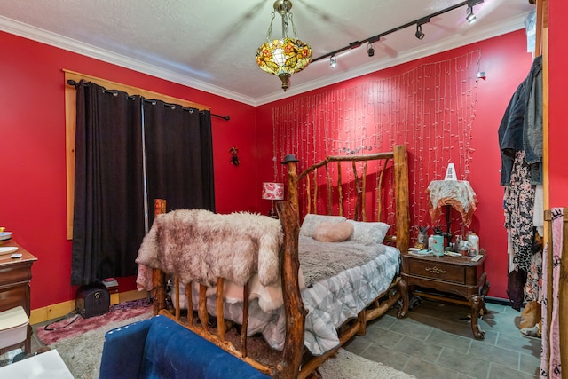 tiled bedroom with ornamental molding, track lighting, and a textured ceiling