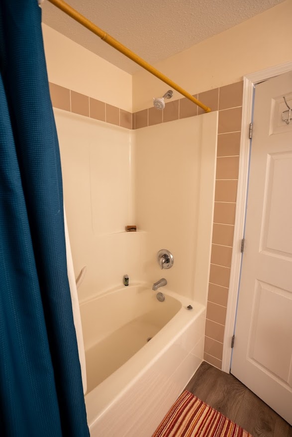 bathroom featuring shower / bath combo with shower curtain and a textured ceiling