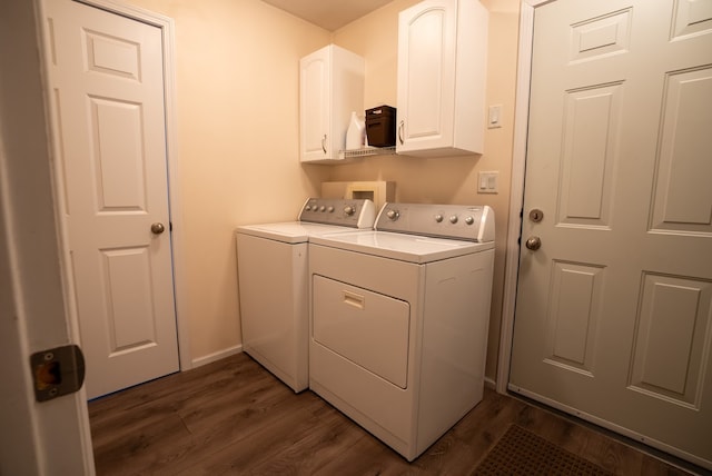 clothes washing area featuring washer and dryer, cabinets, and dark wood-type flooring