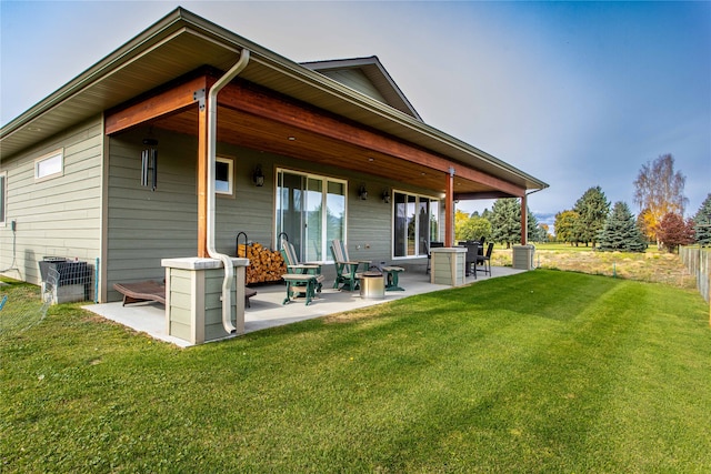 back of property with a patio and a lawn