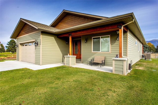 view of front of house featuring central AC, a front lawn, and a garage