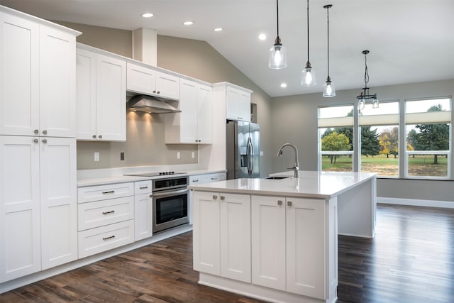 kitchen with appliances with stainless steel finishes, sink, white cabinets, hanging light fixtures, and an island with sink