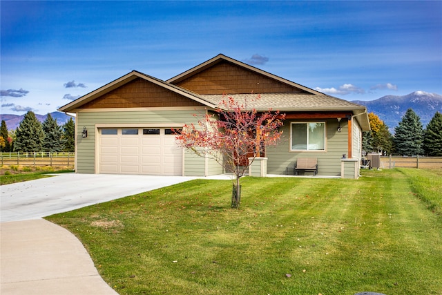 view of front of home featuring a mountain view, a garage, and a front yard