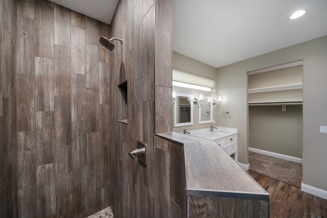 bathroom with a tile shower, vanity, and hardwood / wood-style flooring