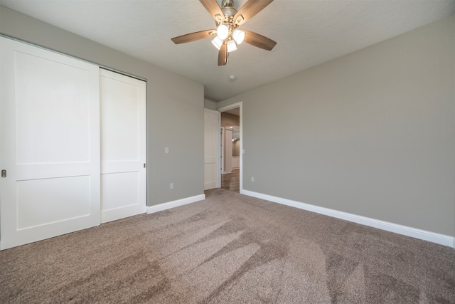 unfurnished bedroom with ceiling fan, a closet, carpet floors, and a textured ceiling