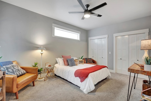 carpeted bedroom featuring ceiling fan and multiple closets