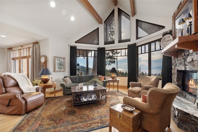 living room featuring beamed ceiling, hardwood / wood-style floors, high vaulted ceiling, and a fireplace