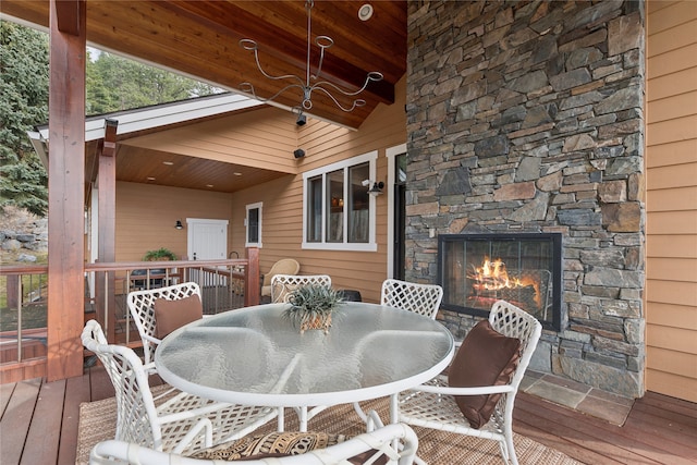 wooden terrace with an outdoor stone fireplace