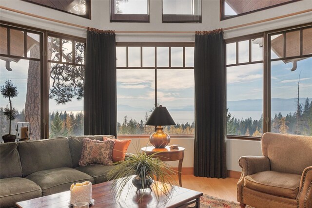 32054 Birch Tree Dr, Bigfork, MT 59911 - living room featuring wood finished floors, beamed ceiling, plenty of natural light, a fireplace, and high vaulted ceiling