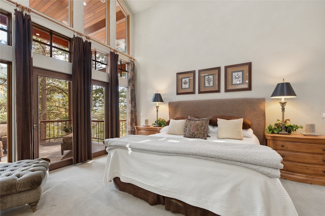 carpeted bedroom with access to exterior and high vaulted ceiling