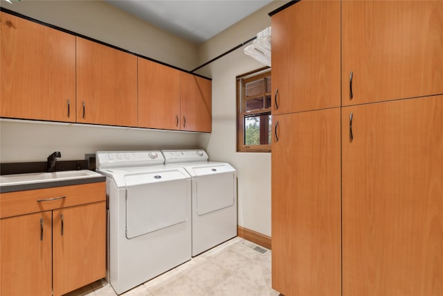 laundry room with cabinets, independent washer and dryer, and sink