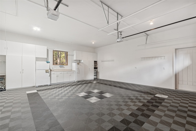 garage with white fridge and a garage door opener