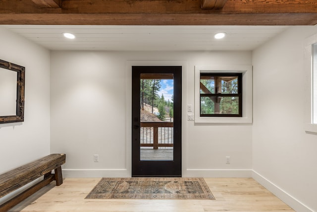 foyer featuring beamed ceiling and light wood-type flooring