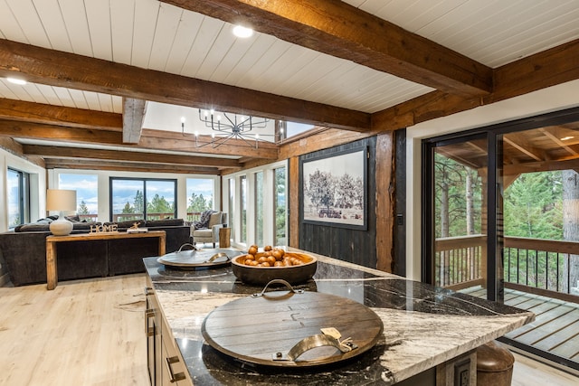 sunroom / solarium featuring beam ceiling, wood ceiling, and a chandelier