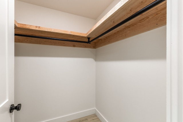 walk in closet with light hardwood / wood-style flooring