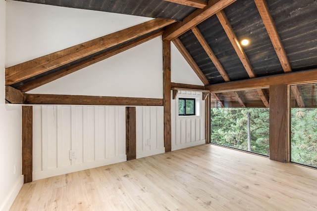 additional living space with lofted ceiling with beams and light hardwood / wood-style floors