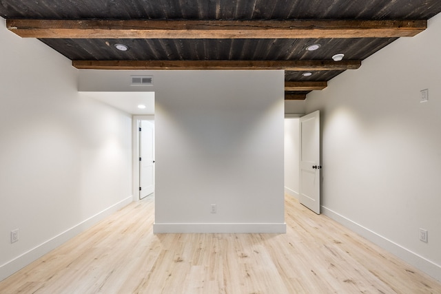 spare room with beamed ceiling, light wood-type flooring, and wooden ceiling