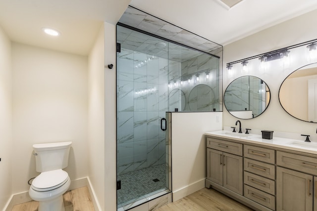 bathroom featuring hardwood / wood-style floors, vanity, a shower with door, and toilet