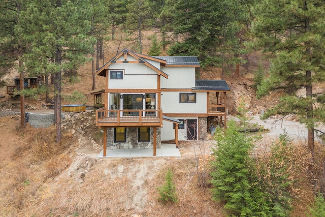 469 Owings Creek Loop, Hamilton, MT 59840 - rear view of property featuring a patio area, stone siding, a deck, and a view of trees
