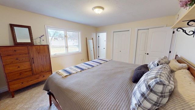 carpeted bedroom featuring two closets