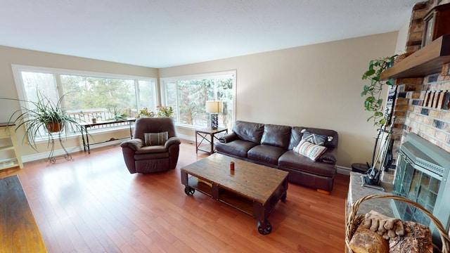 living room featuring hardwood / wood-style flooring and a brick fireplace