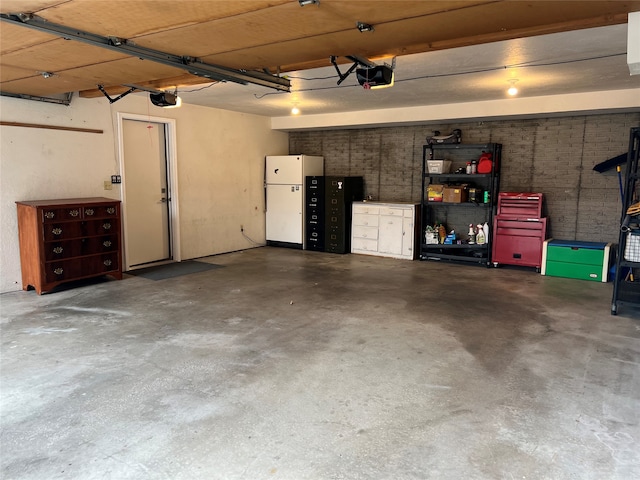 garage with white refrigerator and a garage door opener