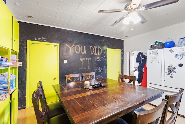 dining area with light wood-type flooring and ceiling fan