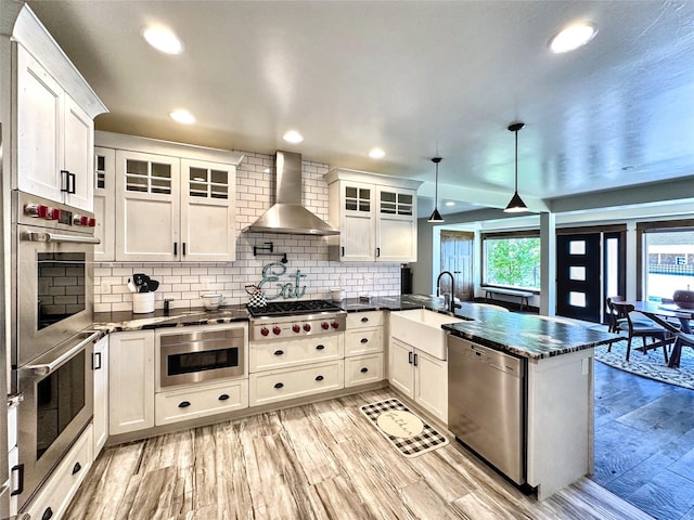 401 Mill St, Sheridan, MT 59749 - kitchen featuring stainless steel appliances, a peninsula, wall chimney exhaust hood, white cabinets, and recessed lighting