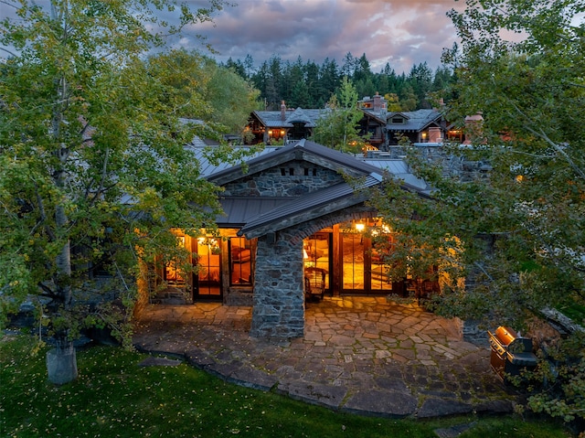 back house at dusk with a patio