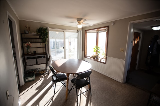 dining area featuring carpet flooring, ceiling fan, and crown molding