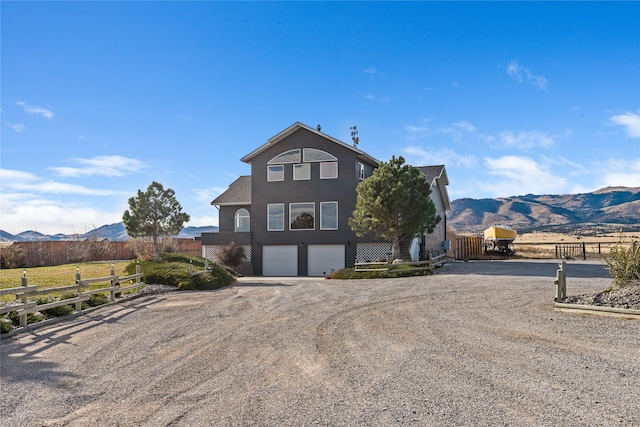 front facade featuring a mountain view, a rural view, and a garage