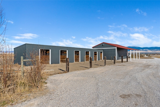 view of front of property featuring a mountain view and an outdoor structure