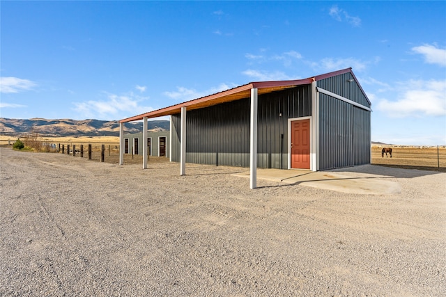 view of outdoor structure featuring a mountain view and a rural view