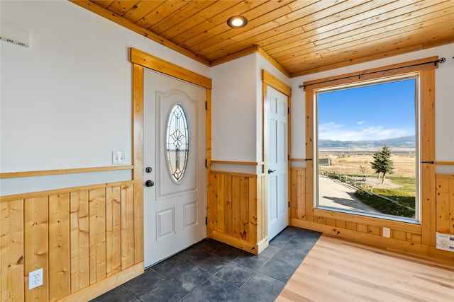 doorway featuring dark tile patterned floors, plenty of natural light, and wooden ceiling