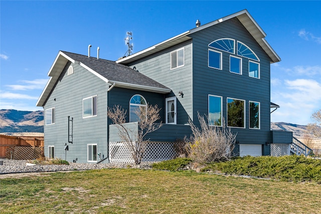 rear view of property featuring a mountain view and a yard