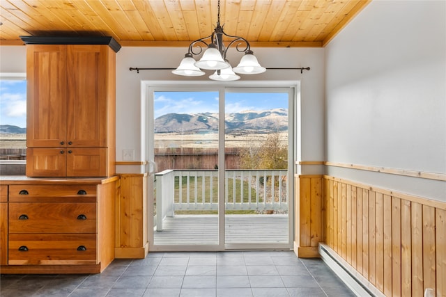 interior space featuring a mountain view, crown molding, wood ceiling, and an inviting chandelier