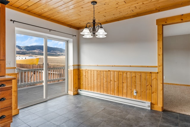 unfurnished room featuring a mountain view, wooden ceiling, a chandelier, and a baseboard heating unit