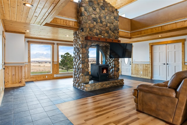 tiled living room with a wood stove and wooden ceiling