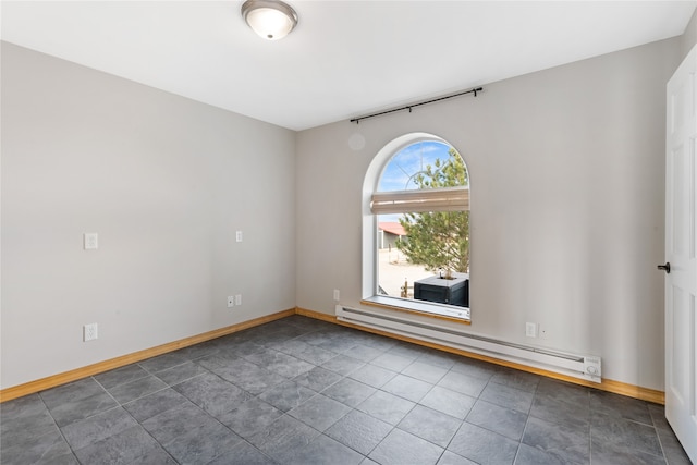 tiled empty room featuring baseboard heating