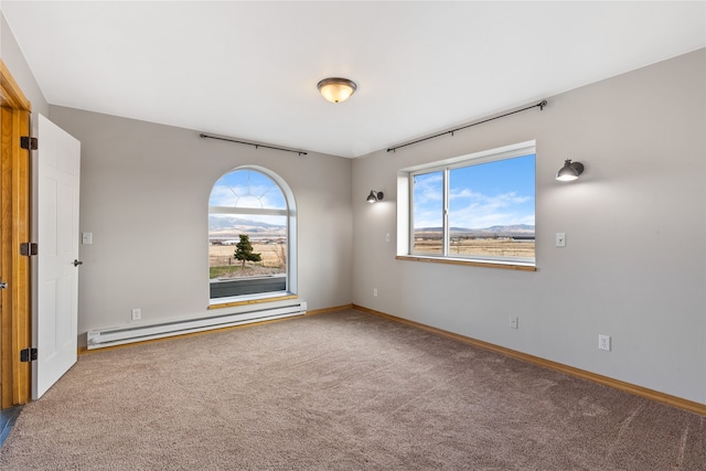 carpeted spare room featuring a baseboard radiator and a healthy amount of sunlight