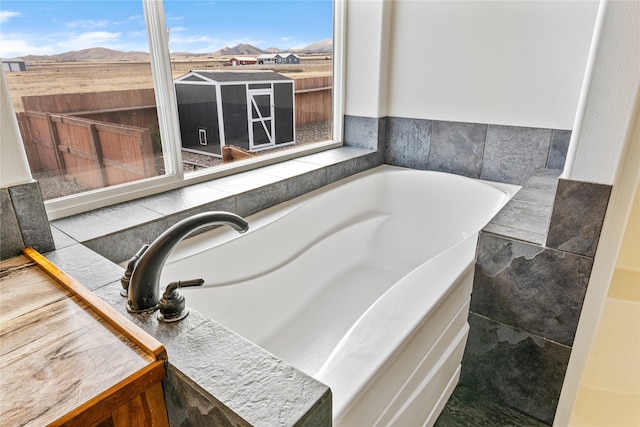 bathroom featuring a tub, a mountain view, and tile walls