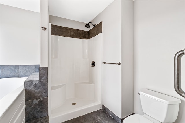 bathroom featuring toilet, tile patterned floors, and walk in shower